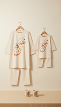 Cream matching set for parent and child with Arabic calligraphy detail, Three-quarter angle on apparel laid flat or hung...